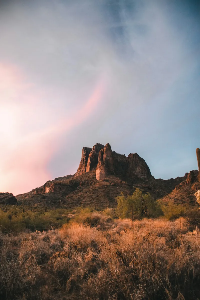 Superstition Mountains at sunset with light breaking through clouds