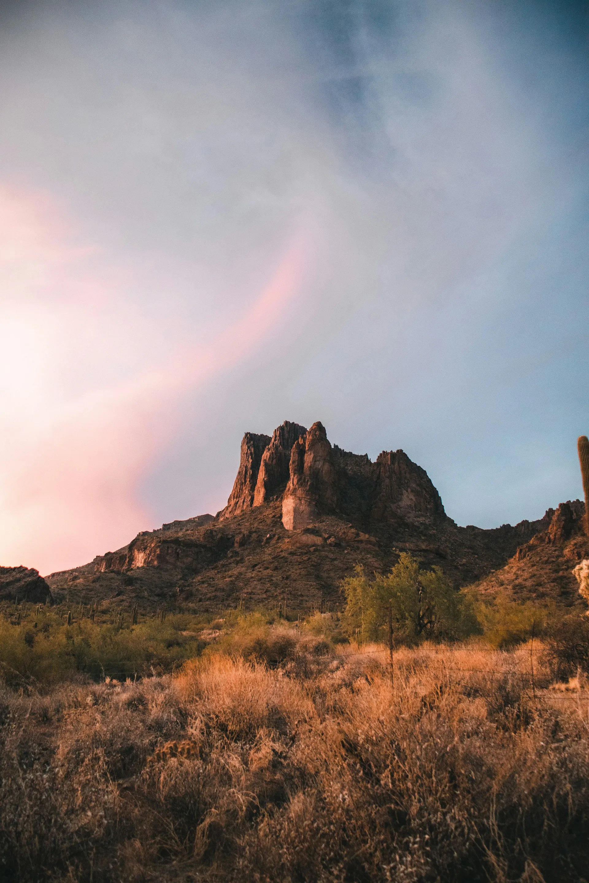 Superstition Mountains at sunset with light breaking through clouds